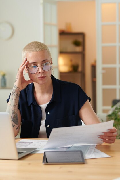 Femme examinant un projet architectural à table