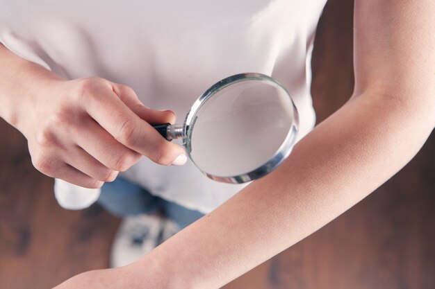 La Femme Examine Sa Main Avec Une Loupe