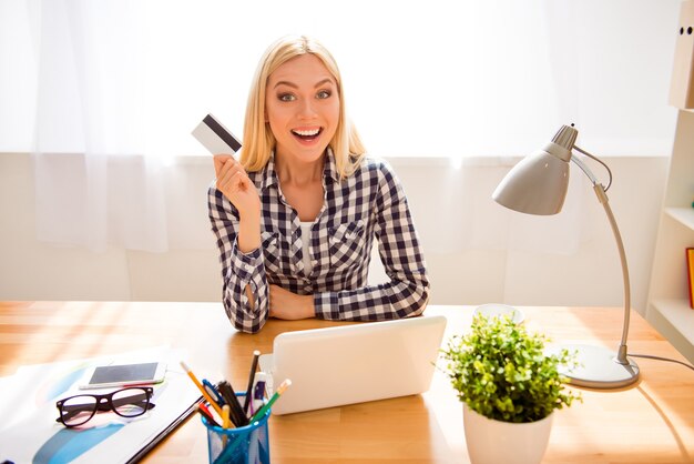 Femme excitée avec carte bancaire ayant une idée de ce qu'il faut acheter