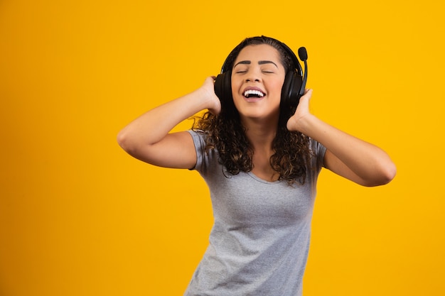 Femme excitée écoutant de la musique au casque.