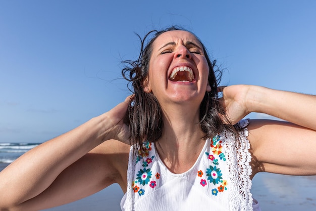 Femme excitée riant de blague sur la plage