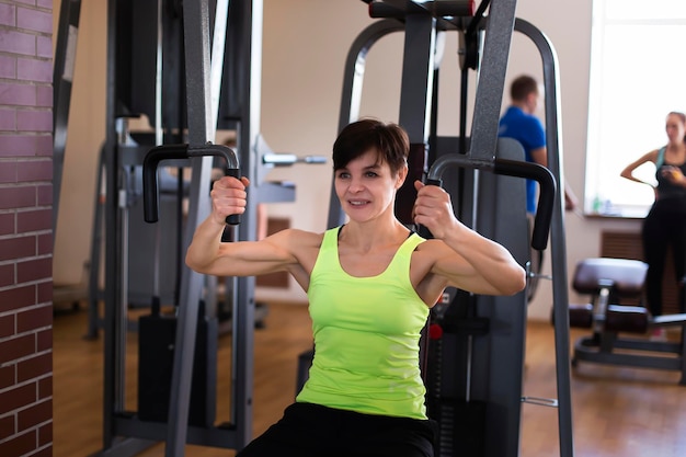 Femme exerçant sur le simulateur faisant des exercices de force