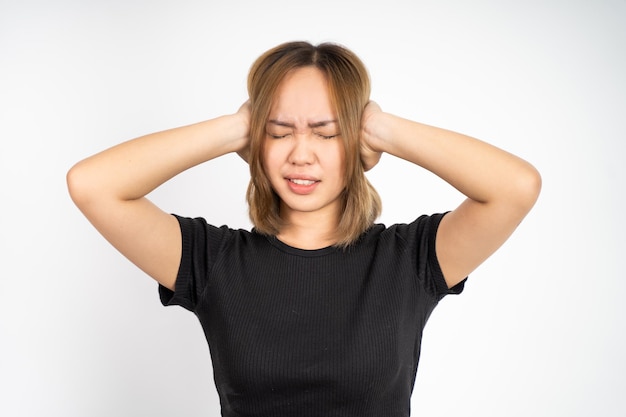 Femme avec une expression agacée couvrant les oreilles avec les deux mains