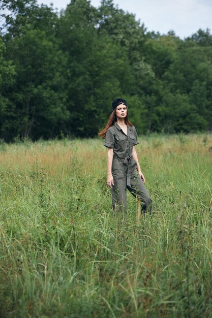 Femme à l'extérieur combinaison verte casquette noire hautes herbes