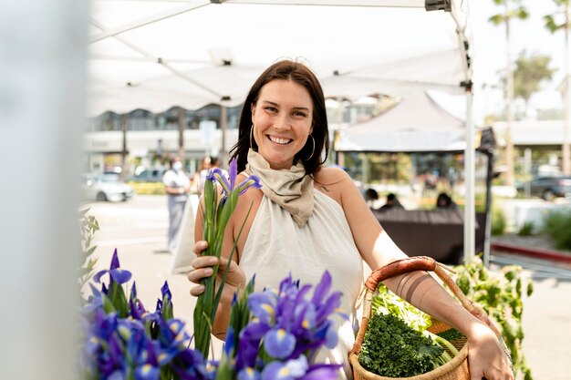 Femme faisant des achats de fleurs sur un marché local