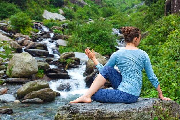 Femme faisant Ardha matsyendrasana asana à l'extérieur