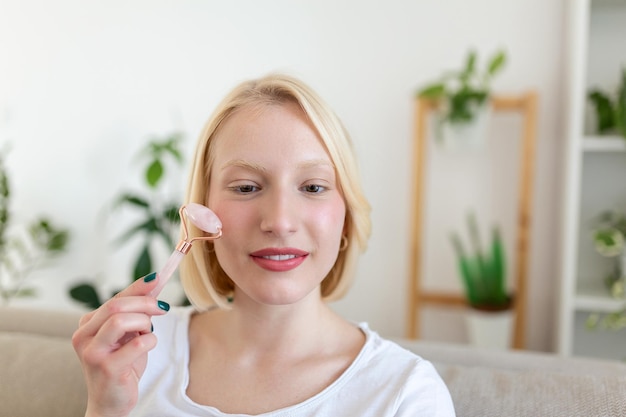 Femme faisant de l'auto-massage avec un rouleau facial en quartz rose