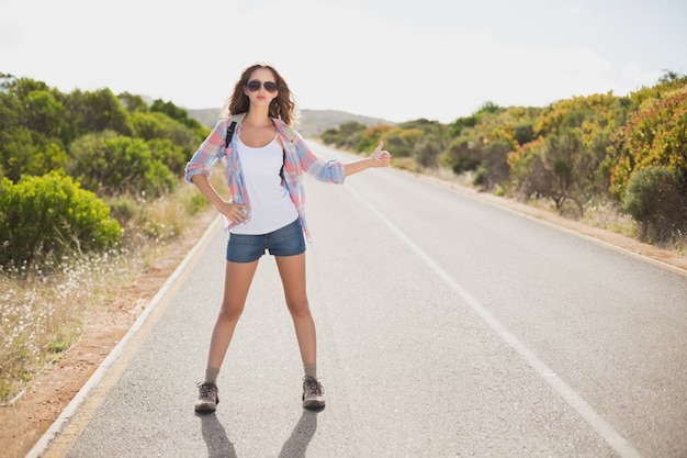 Femme faisant de l'auto-stop sur la route de campagne