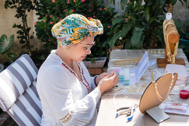 Femme faisant des bijoux en pierre faits à la main atelier à domicile Artisane créant des bijoux Art concept d'artisanat passe-temps