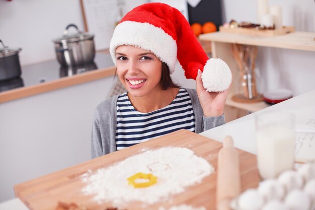 Femme faisant des biscuits de Noël dans la cuisine