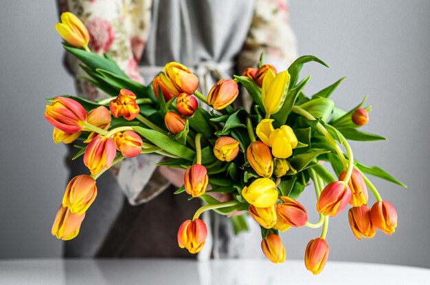 Photo femme faisant bouquet de fleurs de tulipes au printemps