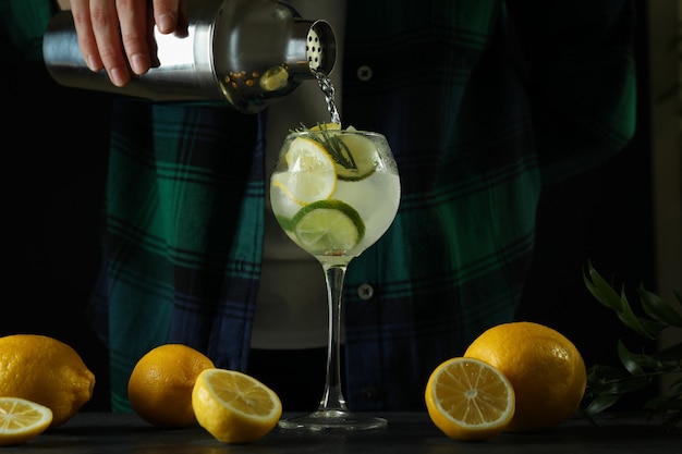 Femme faisant un cocktail aux agrumes sur fond sombre