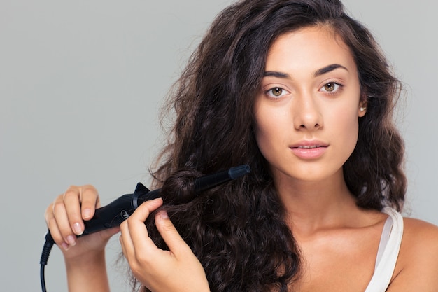 Femme faisant la coiffure avec un fer à lisser