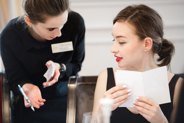 Femme Faisant Une Commande à Partir Du Menu De La Serveuse