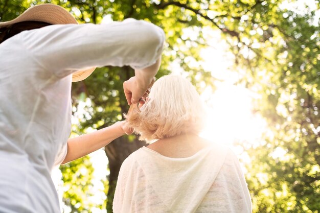 Femme faisant une coupe de cheveux à sa grand-mère