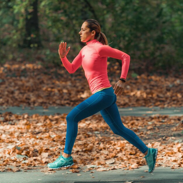 Photo une femme faisant du jogging sur un sentier dans un parc en automne