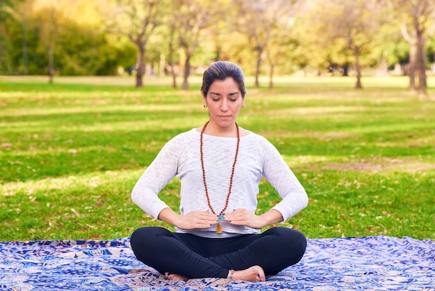 Femme faisant du reiki et du yoga pose dans une pose de chakra de parc