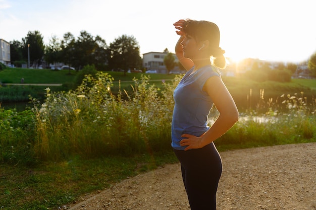 Femme faisant du sport à la campagne au coucher du soleil