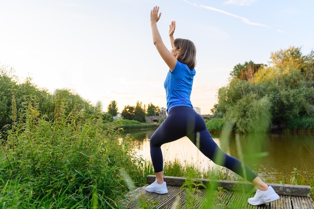 Femme faisant du sport à la campagne au coucher du soleil