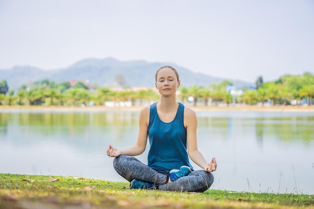 Femme faisant du yoga dans un parc tropical