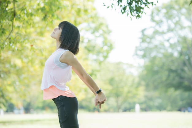 Femme faisant du yoga dans le parc