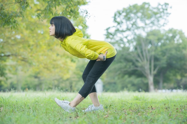 Femme faisant du yoga dans le parc