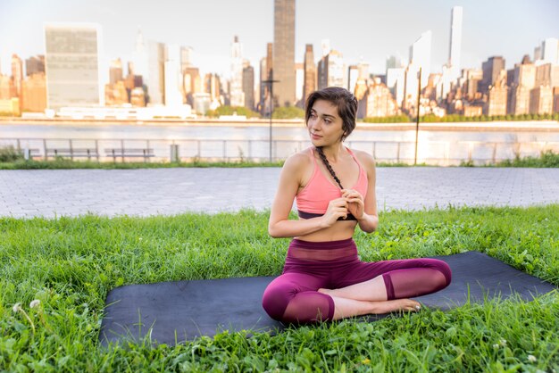 Femme faisant du yoga dans un parc