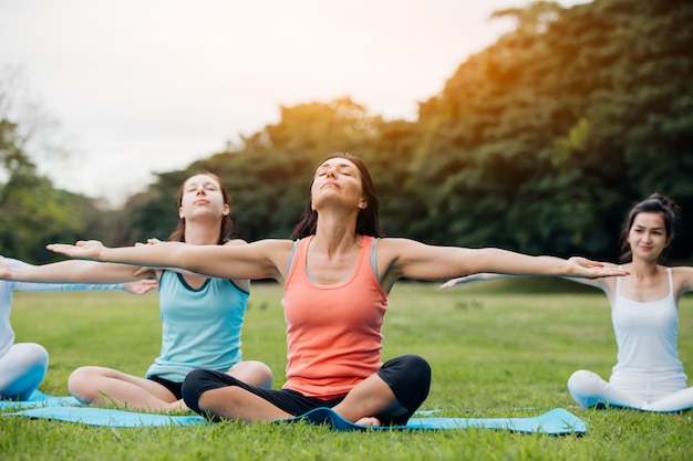 Femme faisant du yoga dans le parc