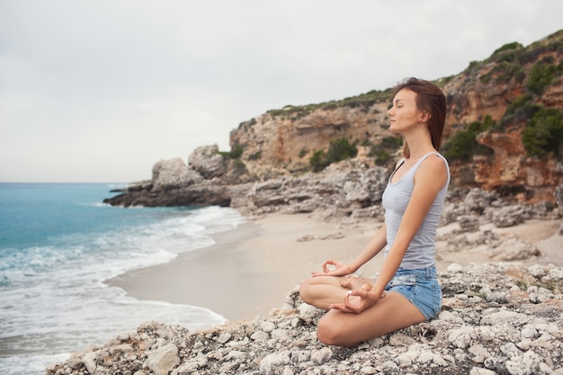 Femme faisant du yoga sur le fond de la mer