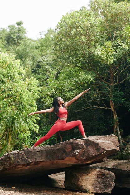 Femme faisant du yoga en forêt