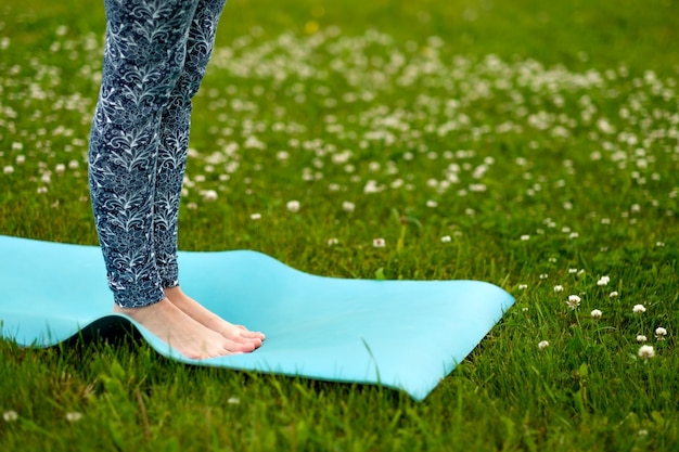 Femme faisant du yoga sur l'herbe verte