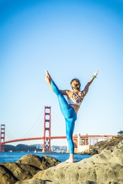 Femme faisant du yoga sur la plage