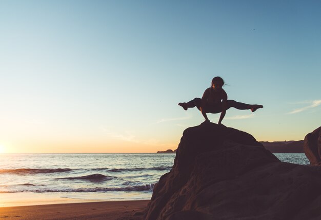 Femme faisant du yoga sur la plage