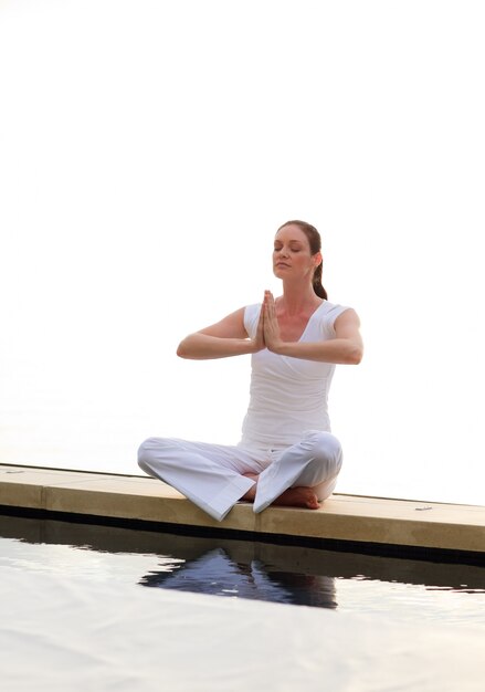 Femme faisant du yoga près de la mer