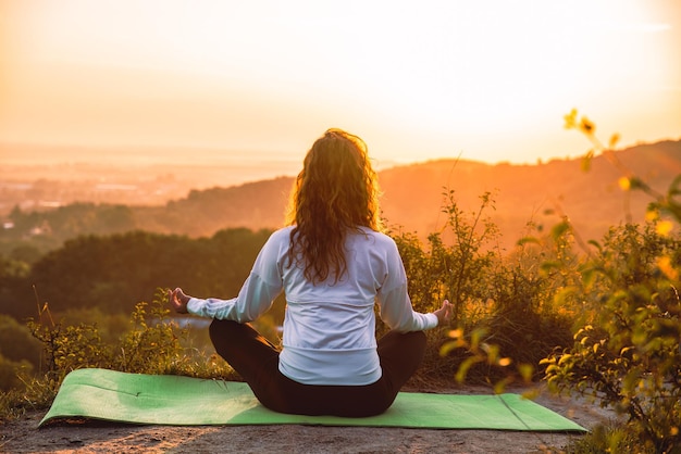 Femme faisant de l'exercice sur la colline au lever du soleil