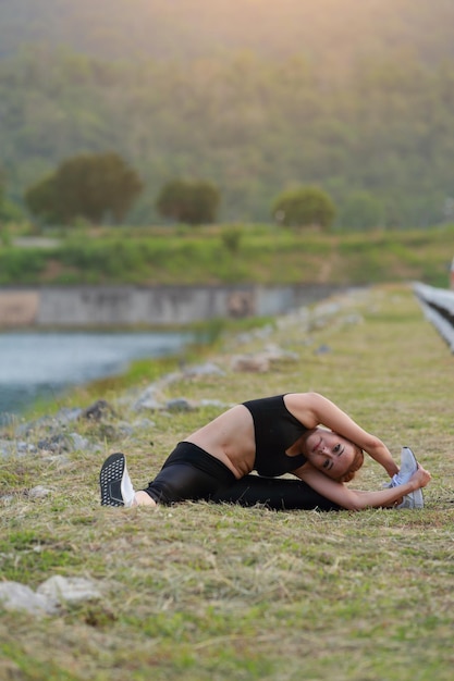 Photo femme faisant de l'exercice de fitness yoga lever du soleil du matin en plein air