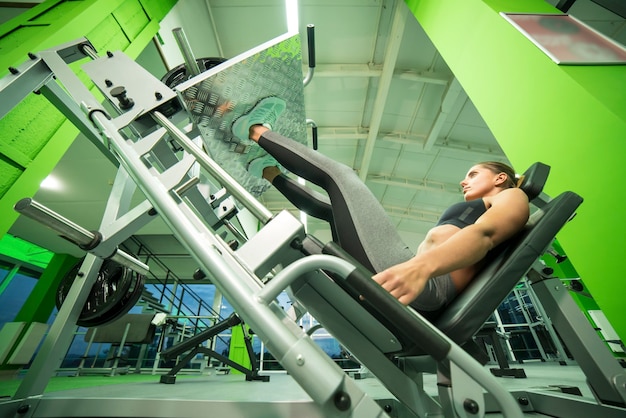 La femme faisant de l'exercice pour les jambes dans le centre sportif