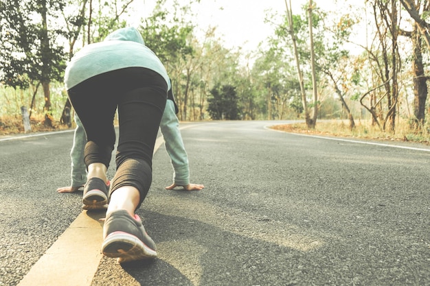 Photo femme faisant de l'exercice sur la route dans la forêt