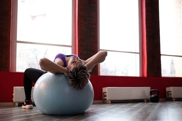 Photo femme faisant des exercices avec fitball en classe de gym fitness