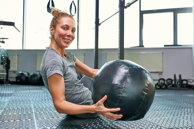 Femme faisant des exercices avec fitball en cours de fitness. Engager les muscles abdominaux de base. Concept d'image de mode de vie sain pour les femmes.