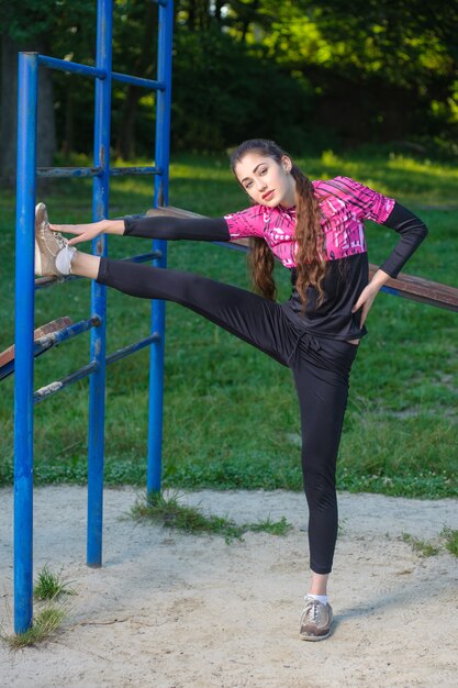 Femme faisant des exercices de fitness dans le parc. Heure d&#39;été