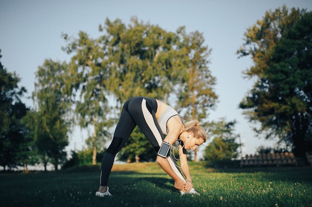 Femme faisant des exercices de yoga dans le parc