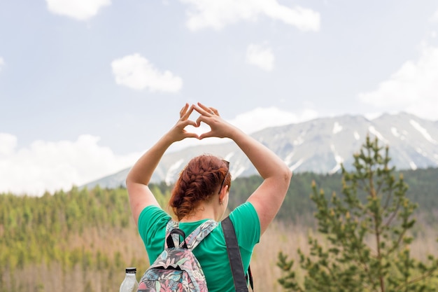 Femme faisant une forme de coeur avec les mains