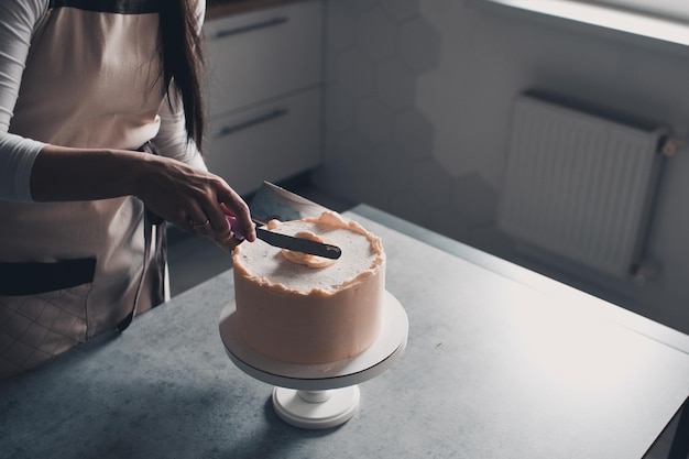 Femme faisant un gâteau d'anniversaire crémeux dans la cuisine libre temps de vacances mise au point sélective