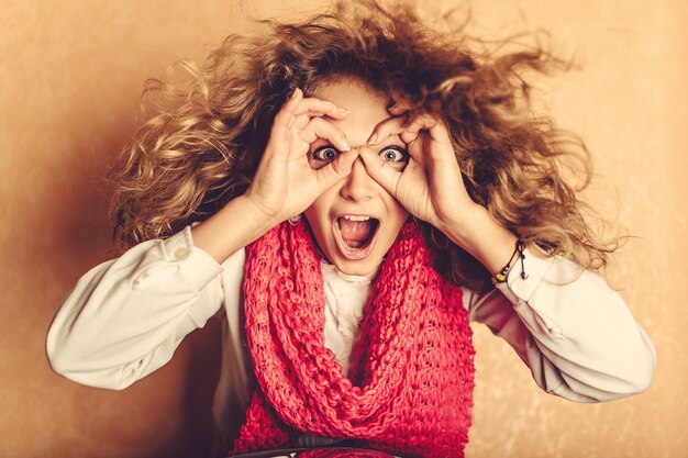 Femme faisant des lunettes avec ses doigts