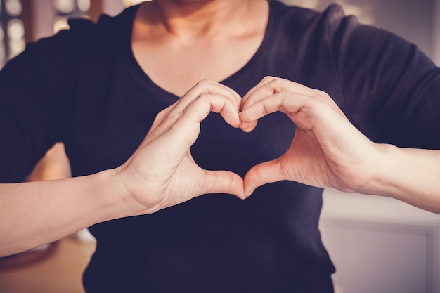 Femme faisant des mains en signe de forme de coeur, journée mondiale du coeur