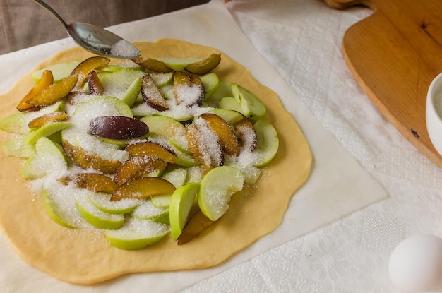 Femme faisant maison gros plan de galette aux pommes et aux prunes