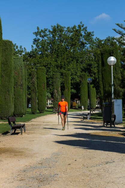 Une femme faisant de la marche nordique dans le parc