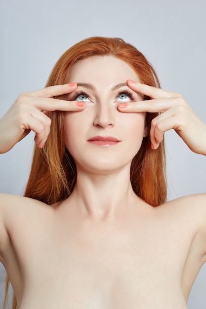 Femme faisant un massage facial, gymnastique, lignes de massage et yeux et nez en plastique