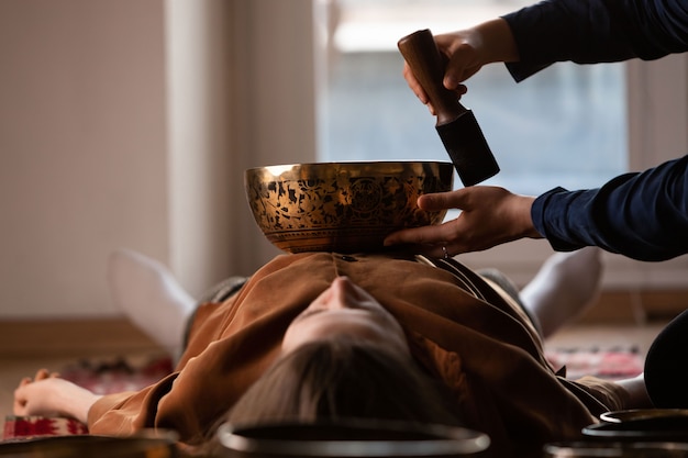 Femme faisant massage relaxant, méditation, thérapie par le son avec des bols chantants tibétains
